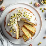 Pistachio Bundt Cake: Moist, Nutty & Nostalgic Treat You’ll Love 7 Top view of a homemade pistachio bundt cake with white vanilla glaze and chopped pistachios, sliced and served on plates